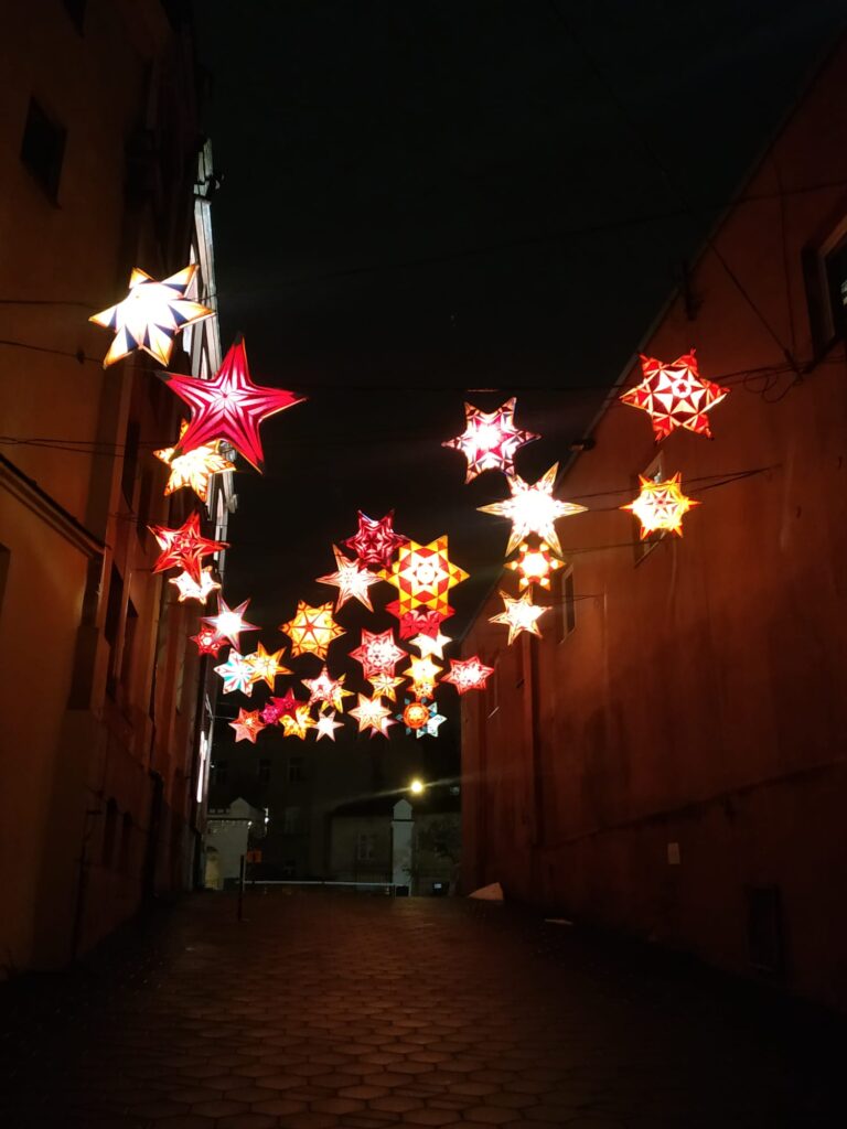 Świecące trójwymiarowe gwiazdy nad uliczką po zmroku. teren Browaru Perła w Lublinie
