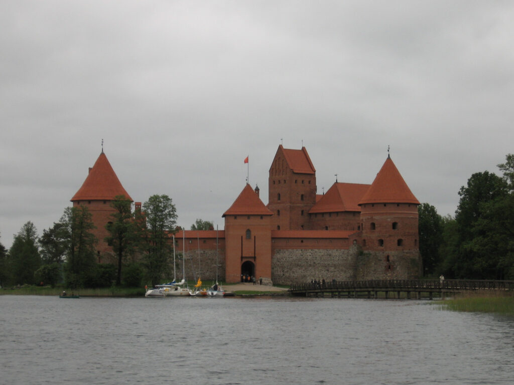 Zamek z czerwonej cegły (przy ziemi zbudowany z kamienia). W środku brama, po bokach wieże obronne.