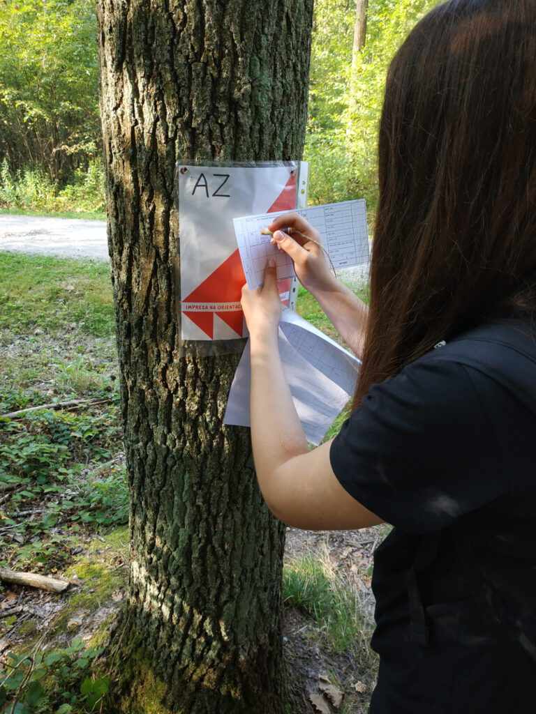 Uczestnik potwierdza punkt kontrolny wiszący na drzewie